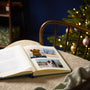 Open book with photos of a dog on a chair with a Christmas tree in the background